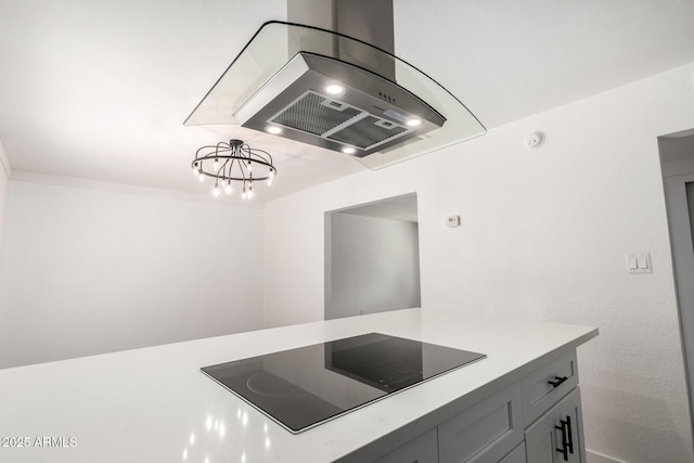 kitchen featuring light countertops, island exhaust hood, and black electric cooktop
