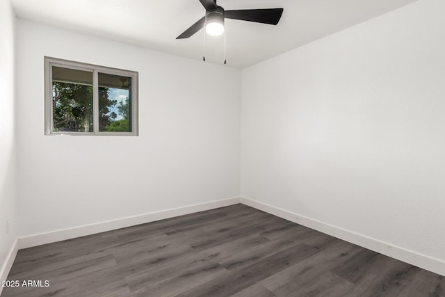 unfurnished room with baseboards, ceiling fan, and dark wood-style floors