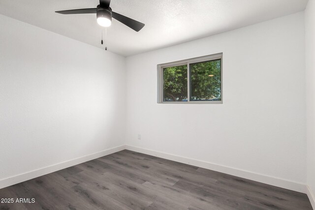 unfurnished room with dark wood-style flooring, baseboards, and ceiling fan