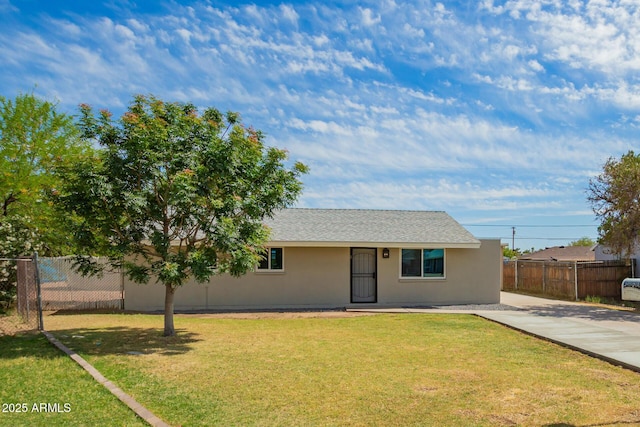 ranch-style home featuring stucco siding, a front lawn, fence, and driveway