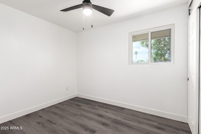 empty room featuring dark wood-style flooring, baseboards, and a ceiling fan