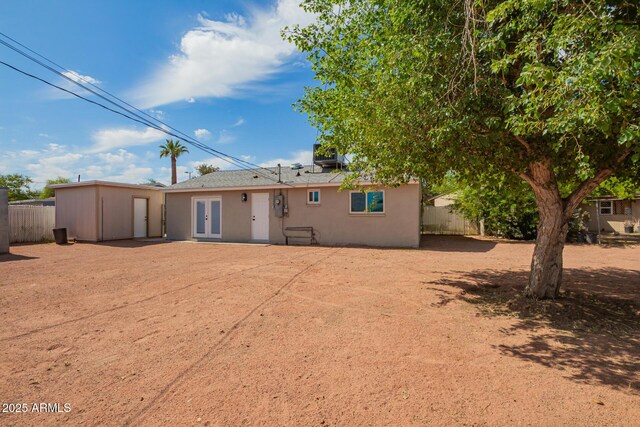 back of house with fence, french doors, and stucco siding