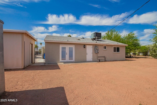 rear view of property with french doors, a gate, central air condition unit, and stucco siding