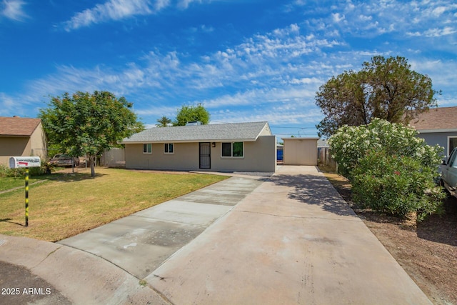 view of front of property featuring stucco siding, fence, driveway, and a front lawn