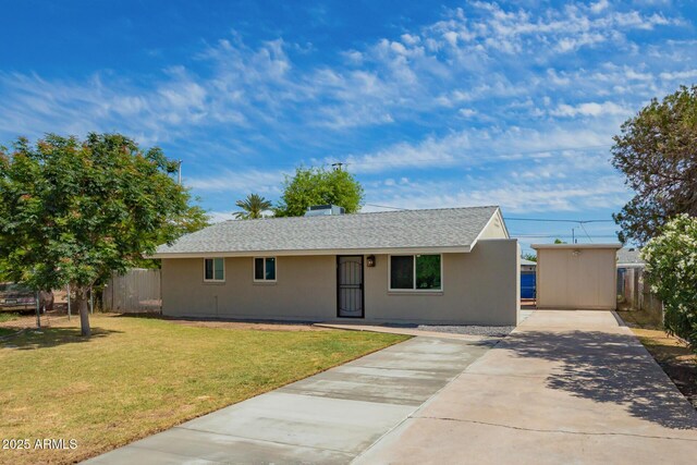 single story home featuring concrete driveway, stucco siding, fence, and a front lawn