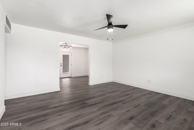 empty room with baseboards, visible vents, ceiling fan, and dark wood-type flooring