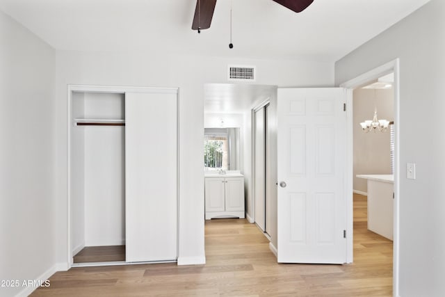 3326 E Calypso Ave, Mesa, AZ 85204 - unfurnished bedroom with ceiling fan with notable chandelier, a closet, light wood-type flooring, visible vents, and baseboards
