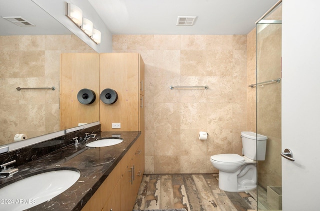 bathroom featuring hardwood / wood-style flooring, vanity, tile walls, and toilet