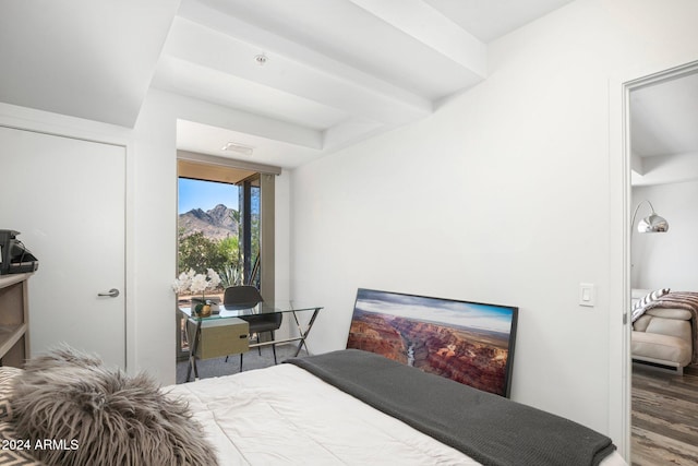 bedroom with beamed ceiling and wood-type flooring