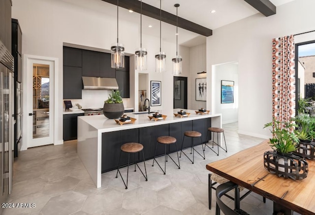 kitchen with a breakfast bar, beamed ceiling, exhaust hood, decorative light fixtures, and sink