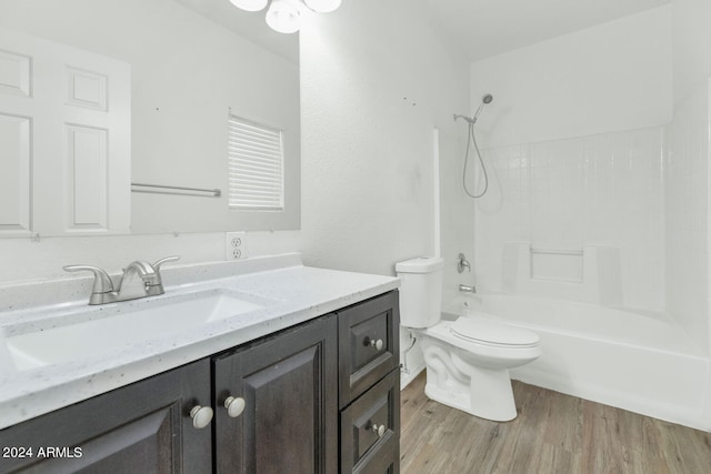 full bathroom with hardwood / wood-style flooring, toilet, vanity, and bathing tub / shower combination