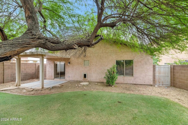 back of property featuring a lawn and a patio area