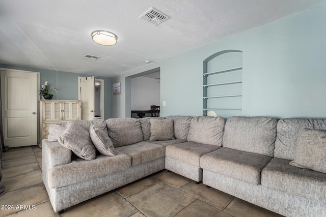 living room with a textured ceiling and built in features