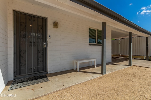 view of exterior entry with a carport