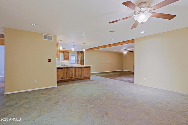 unfurnished living room featuring ceiling fan and beamed ceiling