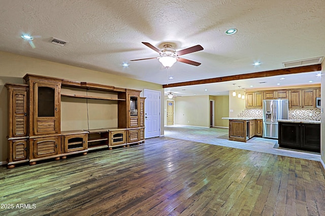 unfurnished living room with a textured ceiling, ceiling fan, and dark hardwood / wood-style floors