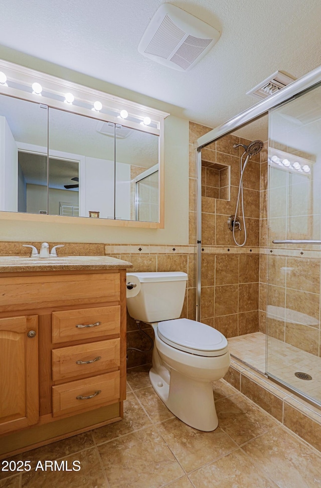 bathroom featuring toilet, an enclosed shower, a textured ceiling, and vanity