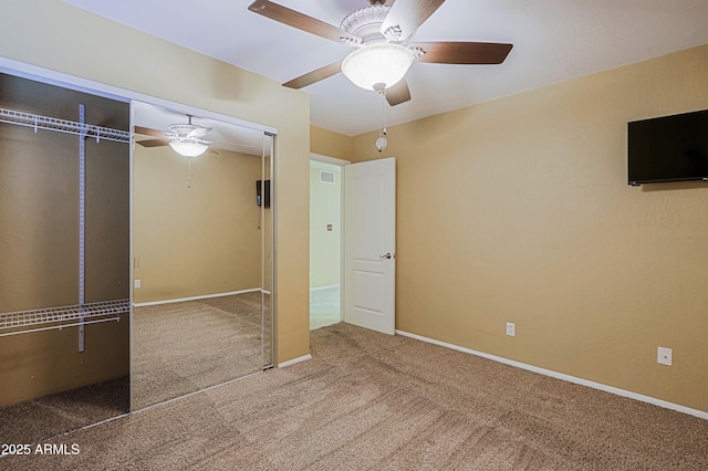 unfurnished bedroom with carpet flooring, a closet, and ceiling fan