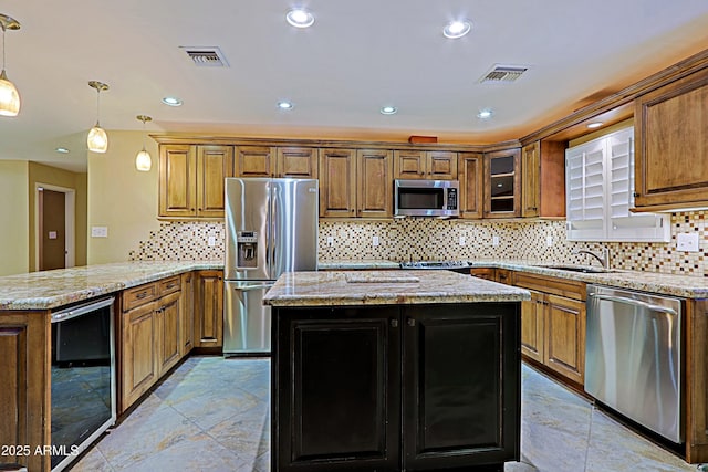 kitchen with beverage cooler, appliances with stainless steel finishes, hanging light fixtures, kitchen peninsula, and sink