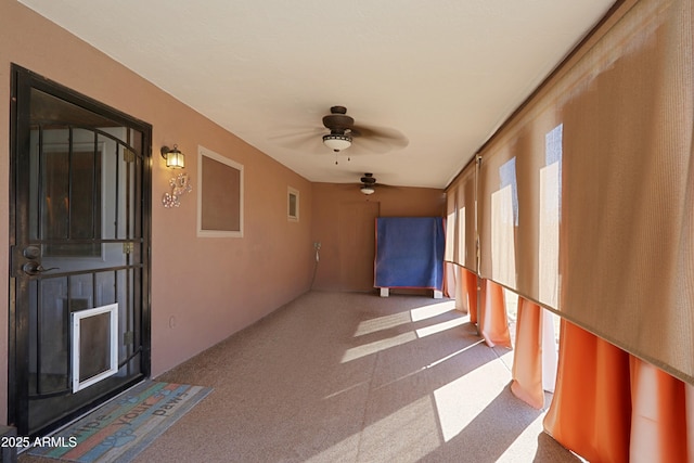 unfurnished sunroom with ceiling fan