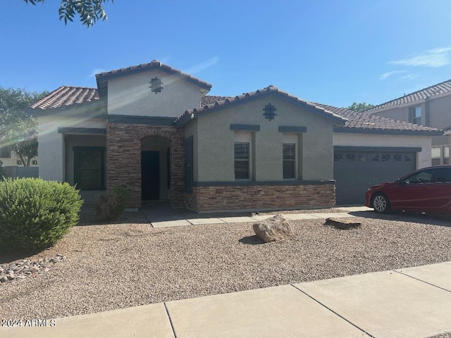 mediterranean / spanish-style home with a garage