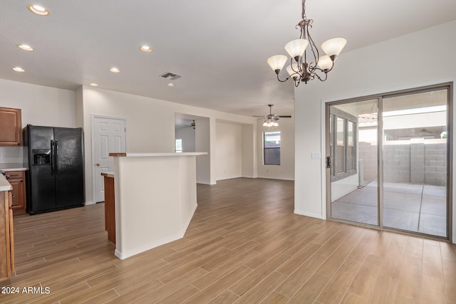 kitchen with visible vents, light countertops, ceiling fan with notable chandelier, light wood-style floors, and black refrigerator with ice dispenser