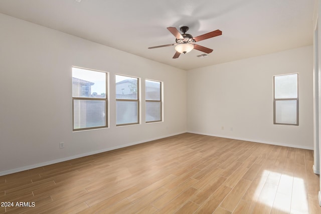 spare room with a ceiling fan, baseboards, and light wood finished floors