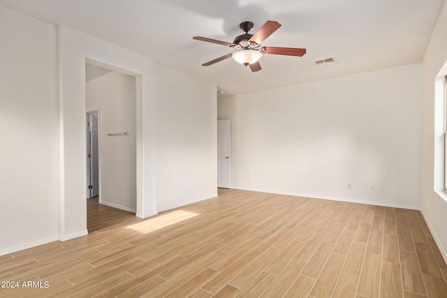 spare room with visible vents, baseboards, light wood-type flooring, and a ceiling fan