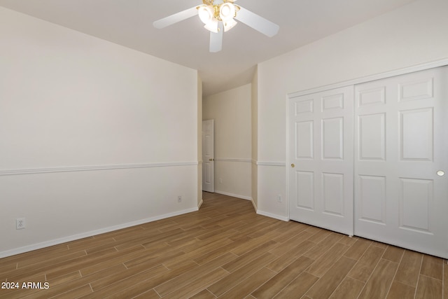 unfurnished bedroom featuring ceiling fan, hardwood / wood-style flooring, and a closet