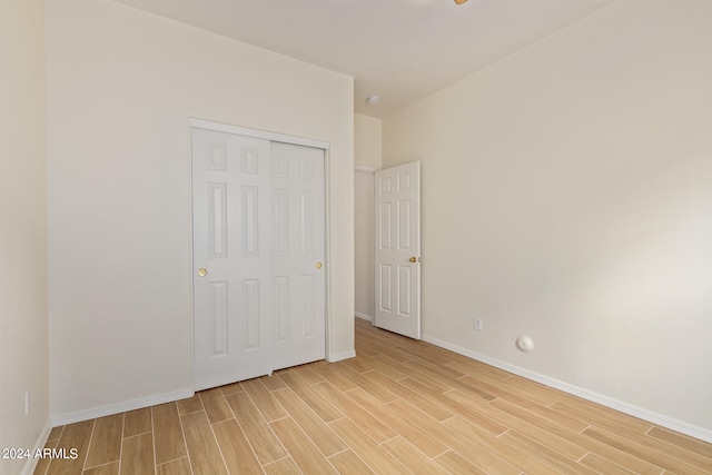 unfurnished bedroom with light hardwood / wood-style floors and a closet