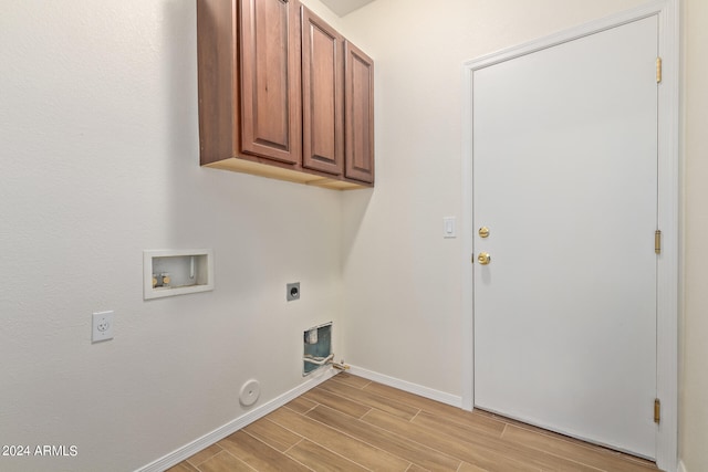 laundry room with hookup for an electric dryer, cabinets, washer hookup, light hardwood / wood-style floors, and hookup for a gas dryer