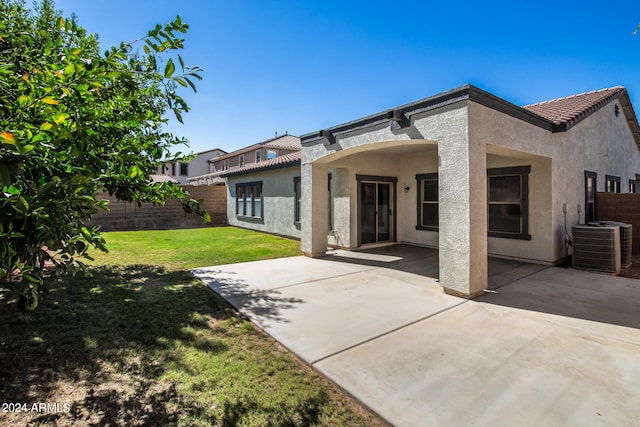 back of house featuring central AC, a patio, and a yard