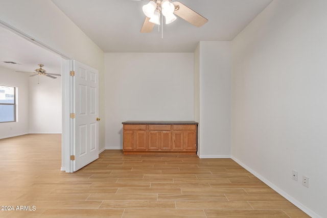 empty room with ceiling fan and light hardwood / wood-style floors