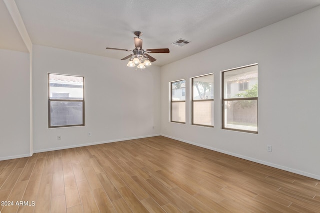 unfurnished room with light wood-type flooring, visible vents, baseboards, and ceiling fan