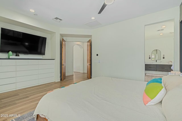 bedroom with connected bathroom, light hardwood / wood-style floors, and ceiling fan