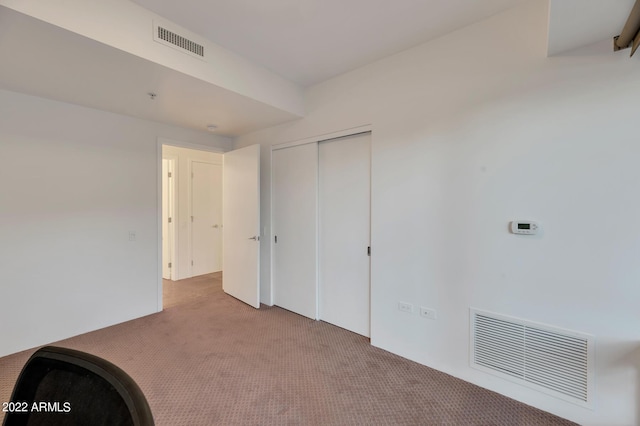interior space with carpet floors, visible vents, and a closet