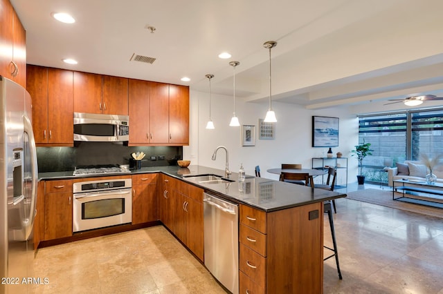 kitchen with visible vents, appliances with stainless steel finishes, brown cabinets, a sink, and a peninsula