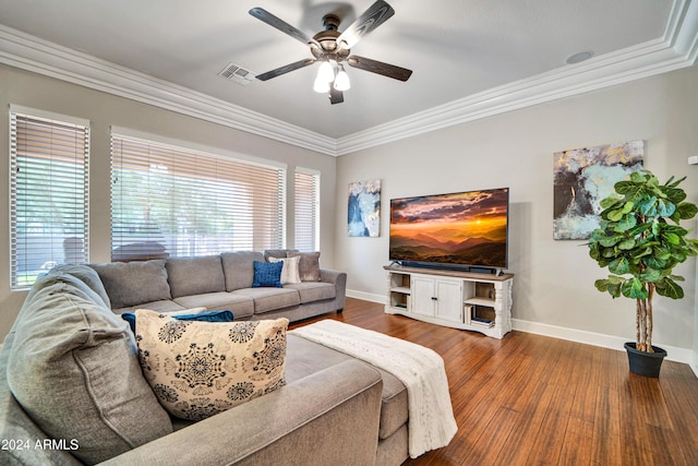 living area featuring dark wood-style flooring, crown molding, visible vents, a ceiling fan, and baseboards