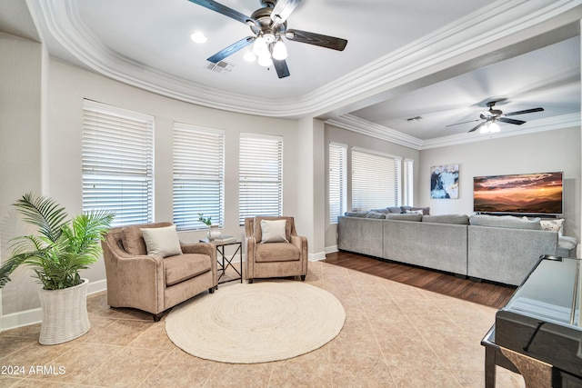 living area featuring ceiling fan, visible vents, baseboards, tile patterned floors, and crown molding