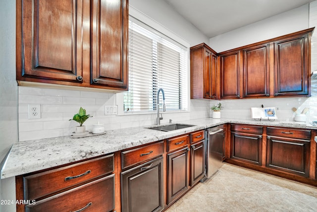 kitchen with decorative backsplash, light tile patterned flooring, a sink, light stone countertops, and dishwasher