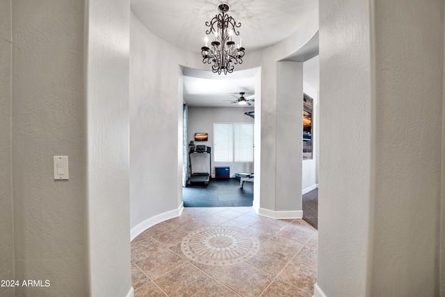 corridor featuring a textured wall and baseboards