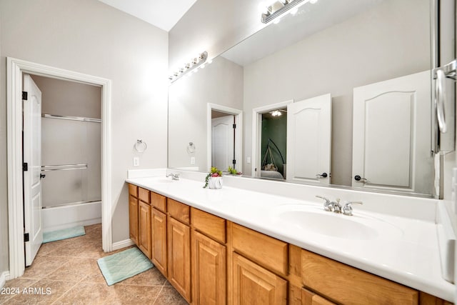 bathroom with tile patterned floors, enclosed tub / shower combo, a sink, and double vanity