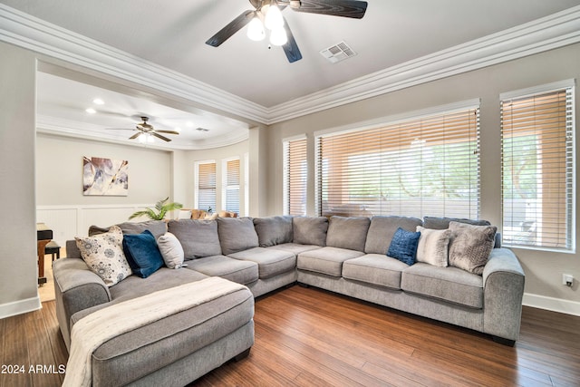 living area with baseboards, visible vents, a ceiling fan, dark wood finished floors, and crown molding