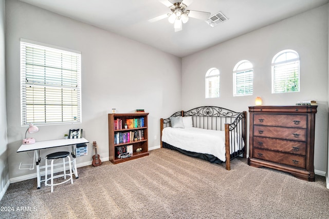 carpeted bedroom featuring baseboards, multiple windows, visible vents, and ceiling fan