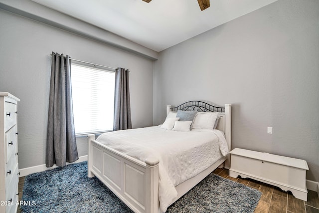 bedroom featuring ceiling fan, baseboards, and dark wood finished floors