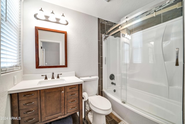 bathroom featuring a textured wall, toilet,  shower combination, a textured ceiling, and vanity