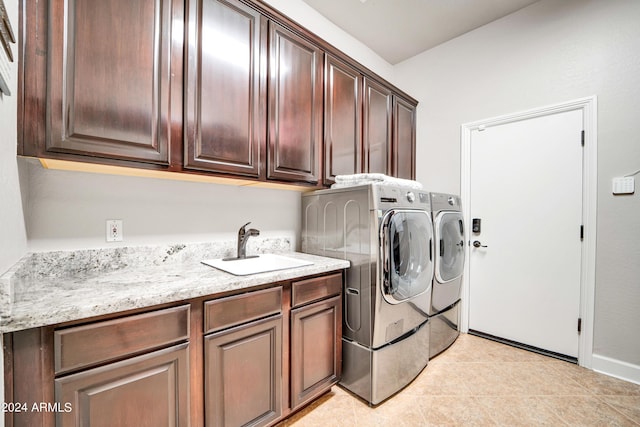 laundry area featuring light tile patterned floors, a sink, cabinet space, and washer and dryer