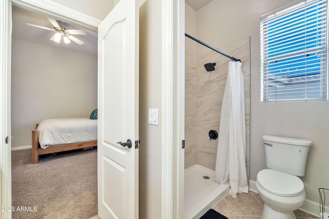 bathroom with toilet, a ceiling fan, a shower stall, baseboards, and tile patterned floors