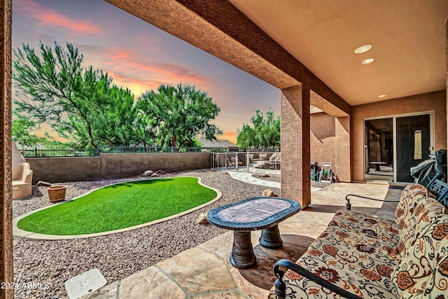 patio terrace at dusk with a fenced backyard