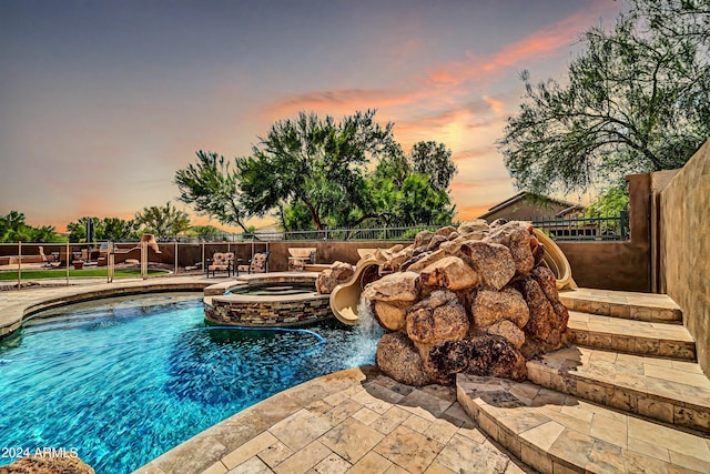 view of pool featuring a patio area, a fenced backyard, and a pool with connected hot tub